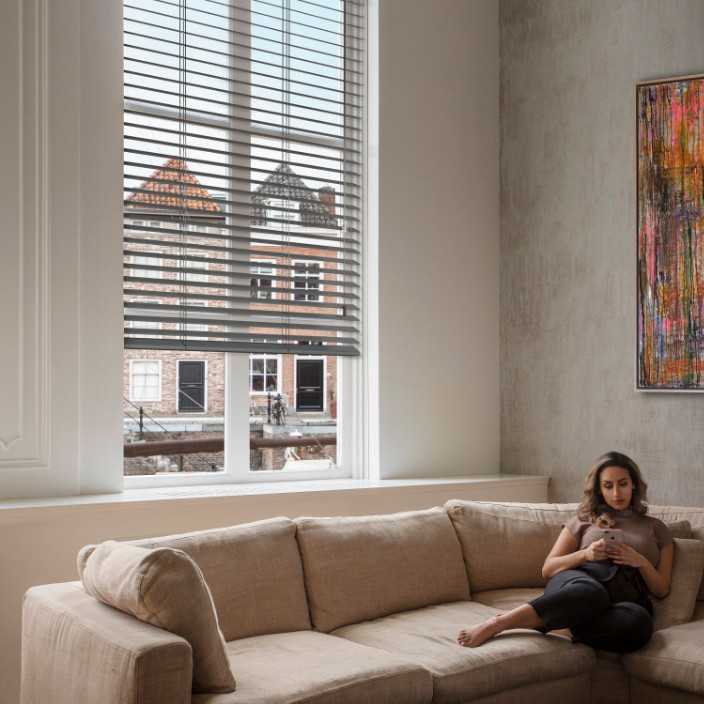 Jaloezieen-grijs-woonkamer-bank-vrouw-704x704-1